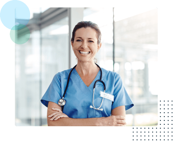 nurse smiling with arms crossed and wearing scrubs and a stethescope